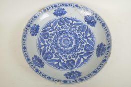 An early C19th Chinese blue and white porcelain charger decorated with lotus flowers and symbols,