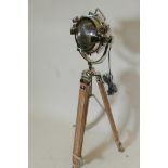 A chrome plated spotlight style standard lamp, on a wood and metal tripod, 42" high minimum