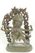 A bronze figure of a warlike Himalayan Buddhist deity, with three faces, six arms and four legs,