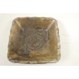 A Chinese white metal square section dish embossed with dragons and calligraphy, 3" square