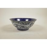 A Chinese deep blue ground porcelain rice bowl with white enamelled dragon decoration, 6 character