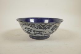 A Chinese deep blue ground porcelain rice bowl with white enamelled dragon decoration, 6 character
