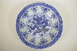 A Chinese blue and white porcelain charger with a lobed rim decorated with a dragon to centre, 14"