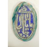 An Islamic green and blue glazed terracotta plaque decorated with calligraphy, 8½" x 13", A/F