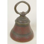 An antique brass bell with engraved and enamelled decoration, 5" high