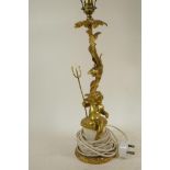 A gilt metal table lamp cast as a cherub with trident seated by a flowering branch, 20" high
