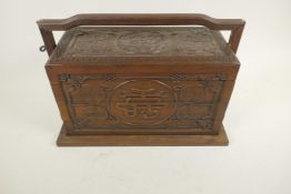 A Chinese three section hardwood box carved with dragons and symbols in a locking frame, 14" x 9½"