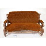 A C19th walnut frame settee with carved open arms, raised on gadrooned front feet and sabre back