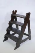 A set of C19th mahogany library steps with four treads on a carved frame