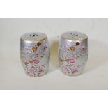 A pair of porcelain garden stools decorated with birds and flowers in bright enamels on a silver