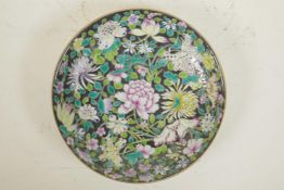 A Chinese famille noire porcelain cabinet plate decorated with Asiatic flowers, 6 character mark