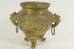 A Chinese bronze incensor with dragon embossed body and two elephant mask ring handles, raised on