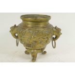 A Chinese bronze incensor with dragon embossed body and two elephant mask ring handles, raised on