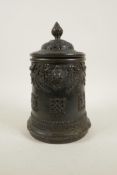 An antique Sino-Tibetan bronze container and cover with three kylin mask handles and decorated