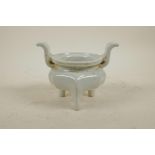A Chinese white glazed porcelain censer with two handles and tripod supports, 5" high