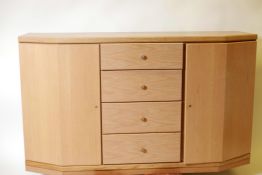 A Hulsta light oak veneered shaped front sideboard, with a flight of four drawers flanked by two