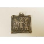 A Javan white metal pendant with repousse figural decoration, 2" wide