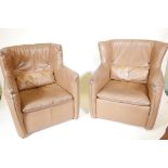 A pair of retro 1970s leather wing back armchairs, 36" high