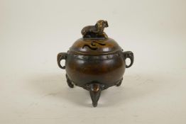 A Chinese bronze barrel shaped censer on elephant head tripod supports and two elephant mask