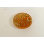 An Islamic amber agate token/counter with engraved and gilt calligraphic inscription, 1"