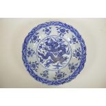 A Chinese blue and white porcelain charger with a lobed rim decorated with a dragon to centre, 14"