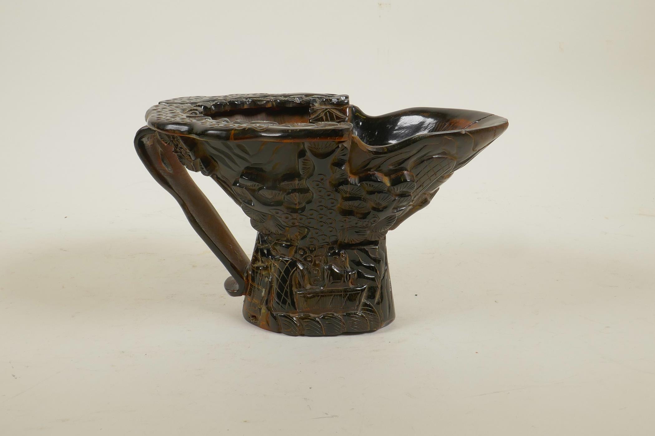A Chinese sectional horn libation cup with carved decoration of figures in a forest, 4½" high x