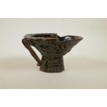 A Chinese sectional horn libation cup with carved decoration of figures in a forest, 4½" high x