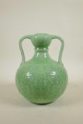 A Chinese green glazed garlic head shaped vase with two handles and underglaze lotus flower