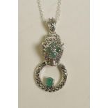 A silver pendant necklace in the form of a jaguar's head, encrusted with marcasite and emeralds,