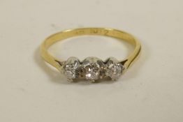 An 18ct gold three stone diamond ring, approximate size 'L/M'