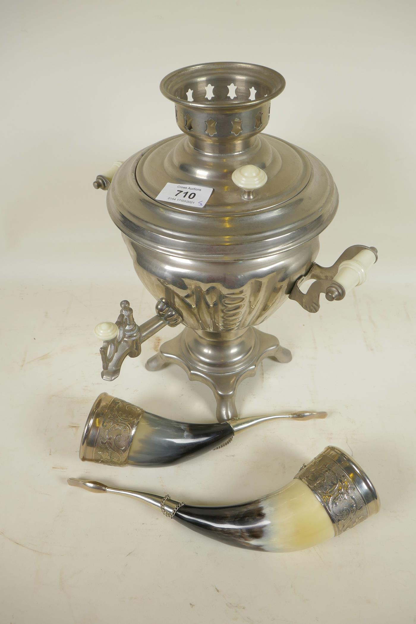 A pair of silver plate mounted horns with scroll decoration, 10" long, together with a silver plated