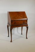 A Queen Anne style walnut fall front bureau, with fitted interior over single drawer, raised on