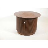 A contemporary walnut cabinet with reeded sides and two doors, 28" diameter, 21" high