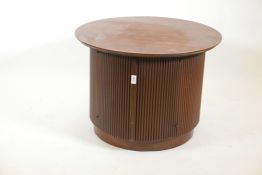 A contemporary walnut cabinet with reeded sides and two doors, 28" diameter, 21" high