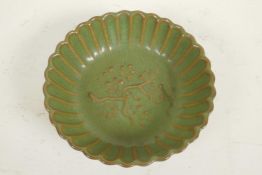 A Chinese green glazed porcelain bowl of ribbed form, the centre decorated with a flowering tree, 5"