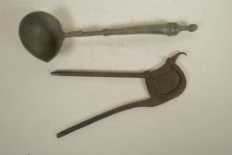 An antique Indian iron betel nut cutter, together with a metal oil ladle, 16" longest
