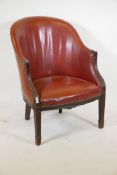A mahogany framed armchair with brass studded leather upholstery, and bow shaped front, raised on
