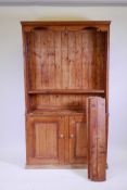 A pine two section dresser, the upper with open shelves, the lower with two cupboards, 42" x 11" x