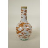 A Chinese polychrome porcelain bottle vase, decorated with an iron red dragon chasing the flaming