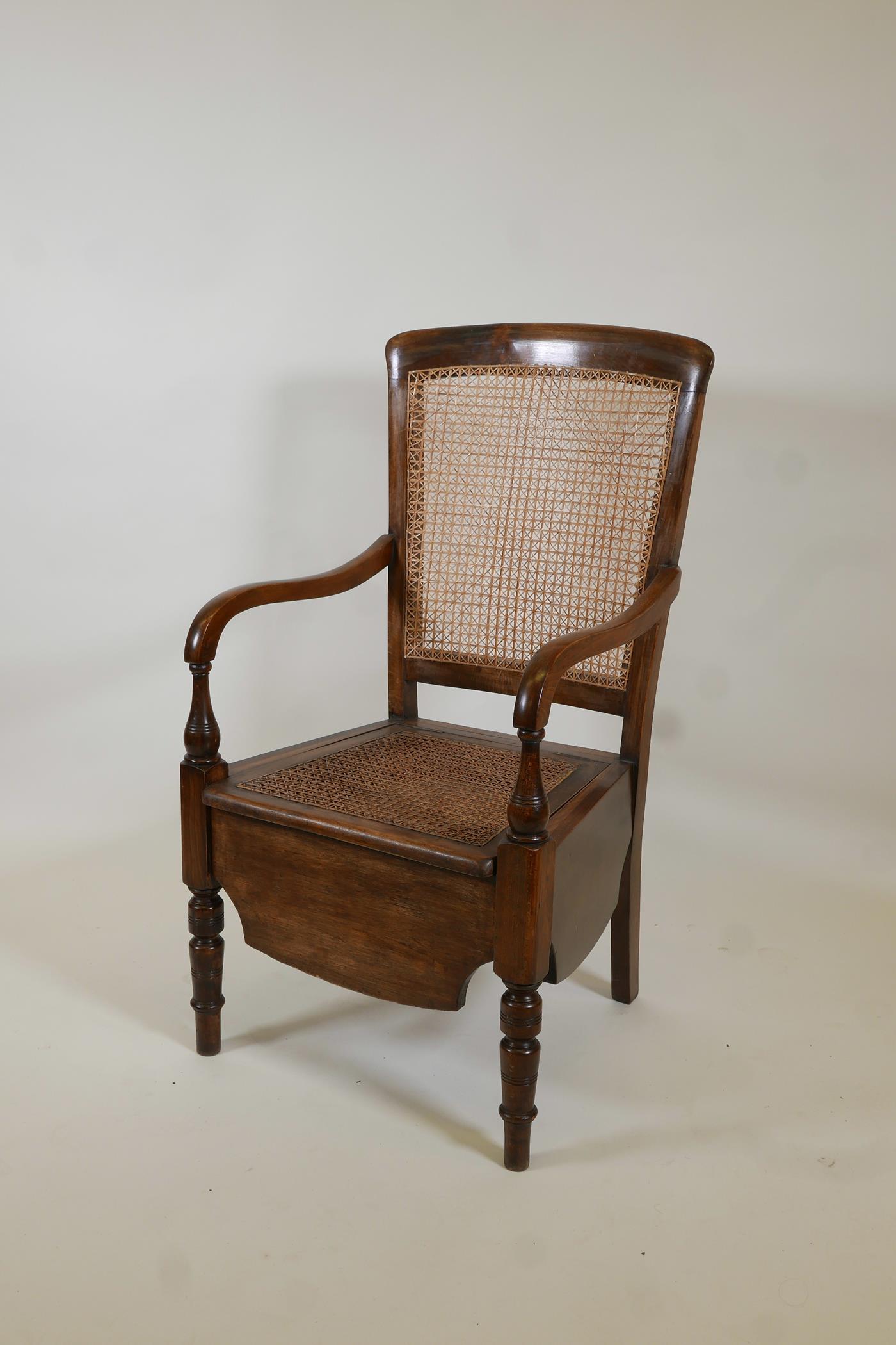 A beech framed commode armchair with bergere panel back by Carter's Ltd, 39" high