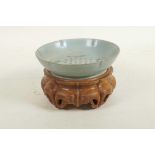 A Chinese Ru ware style dish of lobed form with engraved character inscription decoration, on a