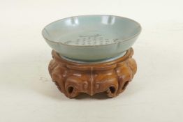 A Chinese Ru ware style dish of lobed form with engraved character inscription decoration, on a