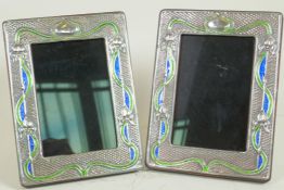 A pair of Art Nouveau style sterling silver photo frames with blue and green enamelled decoration,