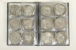 A wallet of Chinese facsimile (replica) white metal coins, sixty total, 1½" diameter