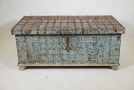 An Indian teak dowry chest with iron strap work wand hinged fold over top, with original