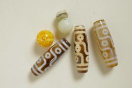 Three Tibetan Dzi beads and two others, 2" long