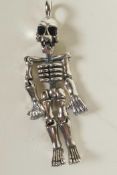 A silver articulated pendant in the form of a human skeleton, 2" long