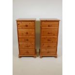 A pair of pine tallboys with five drawers raised on ball feet, 18" x 15" x 38"high