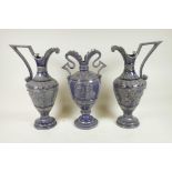 A German pottery garniture consisting of two ewers and matching urn, with an indigo glaze and