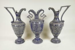 A German pottery garniture consisting of two ewers and matching urn, with an indigo glaze and